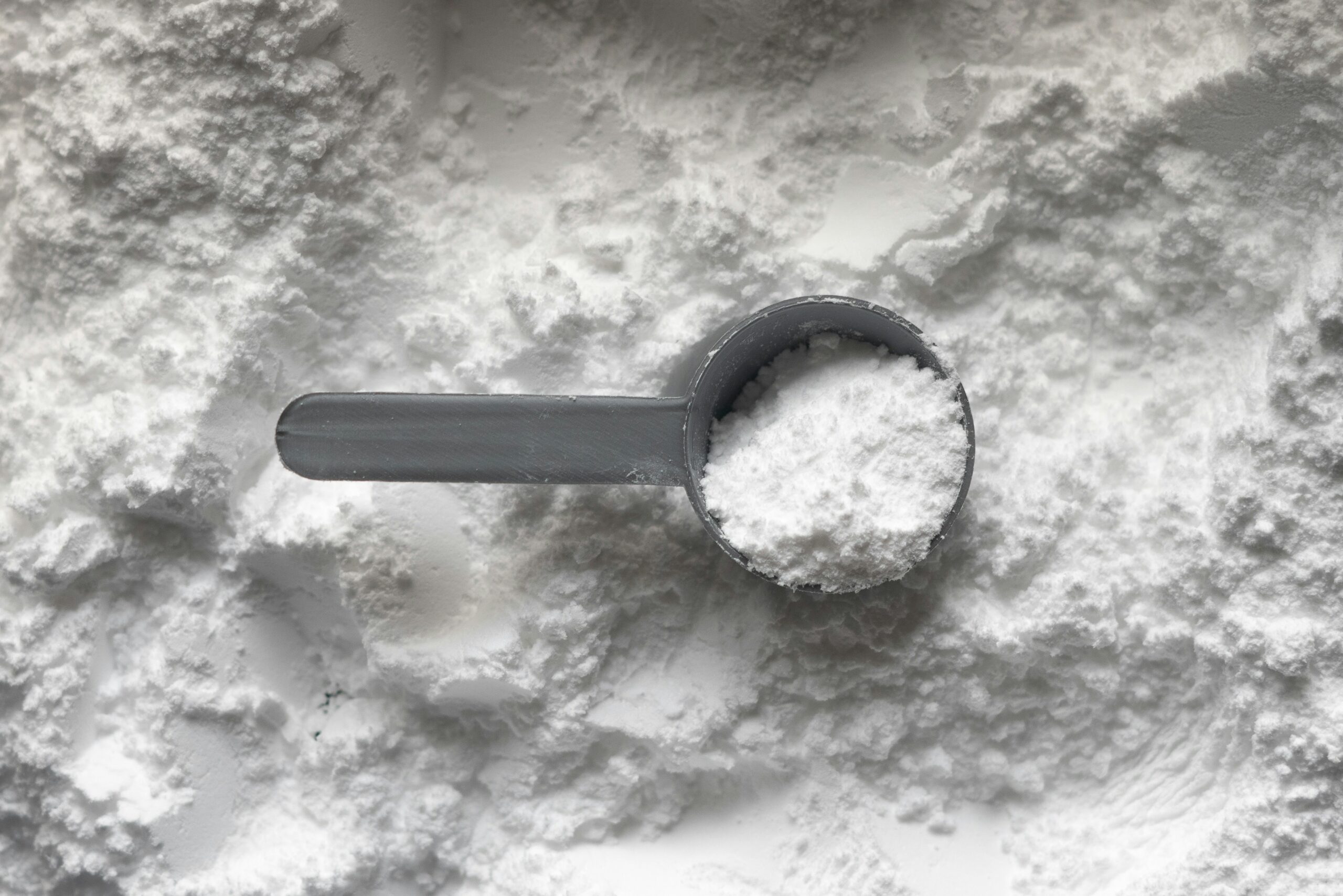 Creatine monohydrate powder with a measuring scoop for men over 35