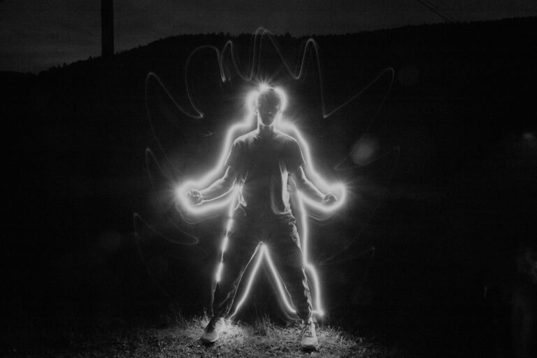 Man standing with arms out surrounded by glowing light — energy and testosterone health for men over 40