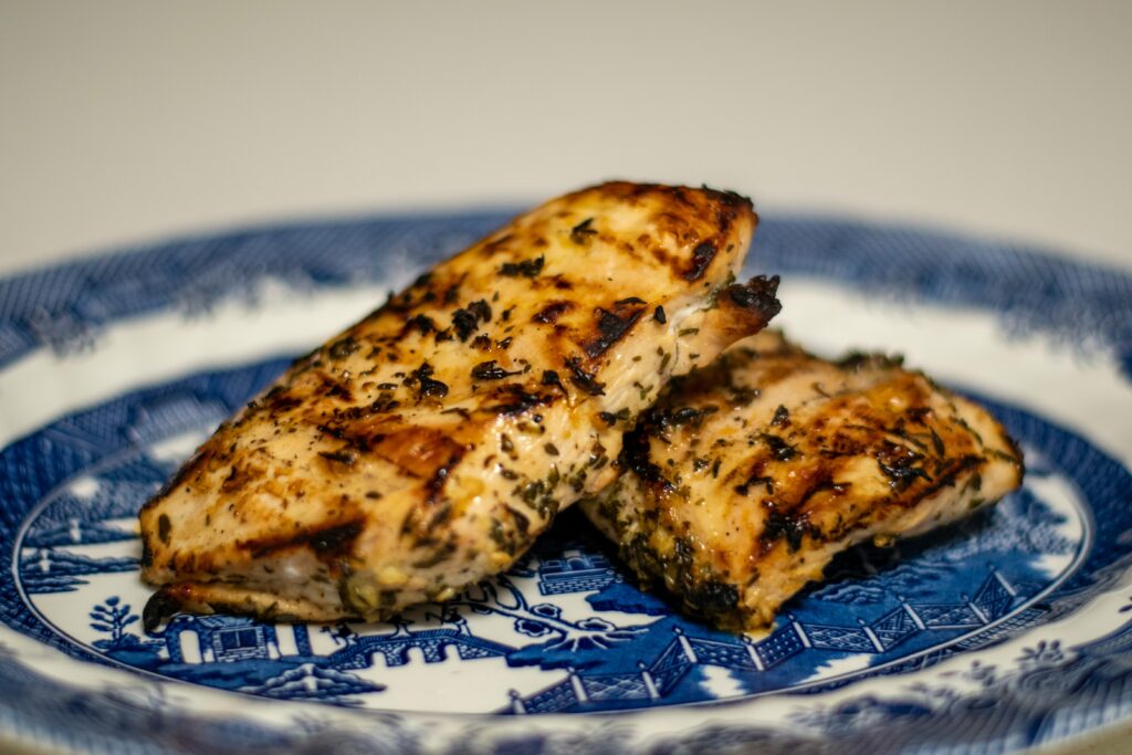 Grilled herb chicken breast on a plate representing high protein food for men over 40