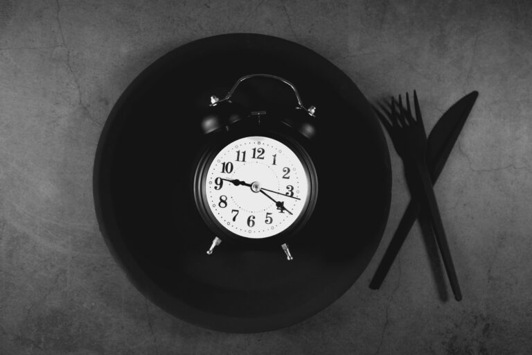 Clock on a plate representing intermittent fasting eating window for men