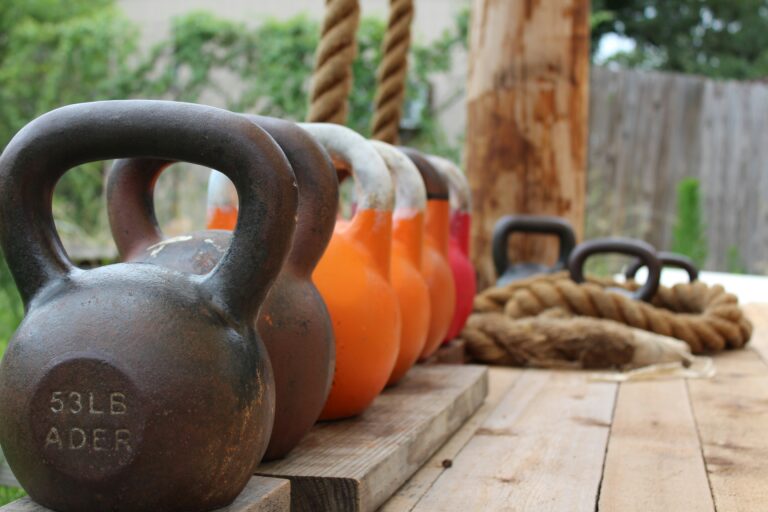 Row of kettlebells in different weights lined up outdoors for home workouts