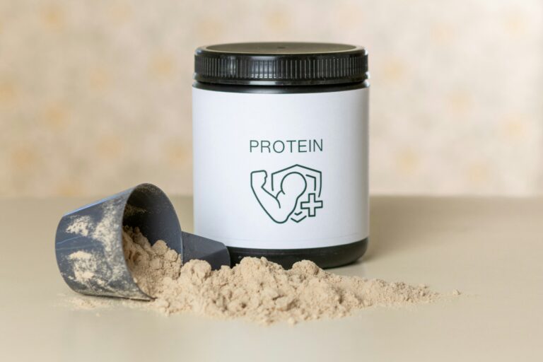 Protein powder tub with scoop and powder spilled out for men's supplement comparison