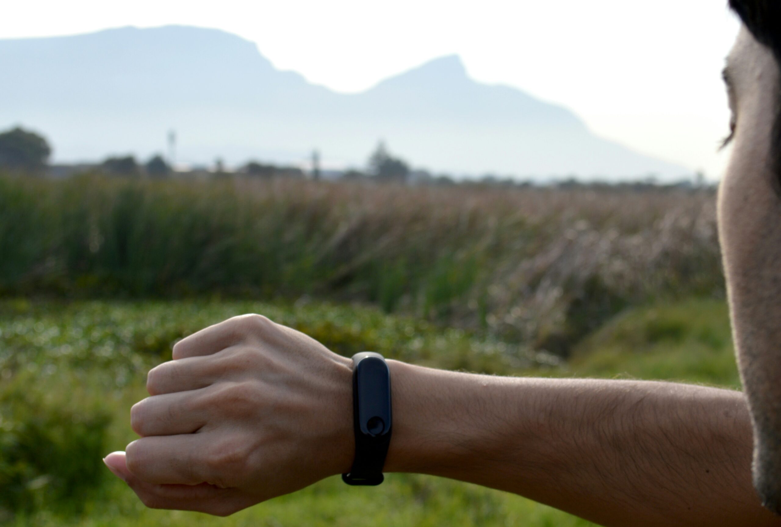 Man wearing a fitness tracker watch outdoors checking activity stats